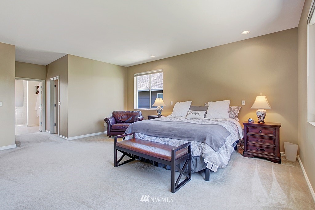 27712 Maple Ridge Way Southeast Maple Valley, WA 98038 - Photo 21 of 36 a spacious bedroom with a bed and window