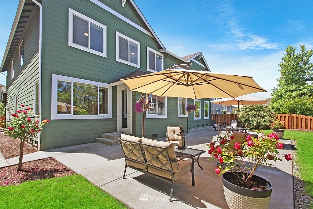 27712 Maple Ridge Way Southeast Maple Valley, WA 98038 - Photo 30 of 36 a patio with a table and chairs under an umbrella