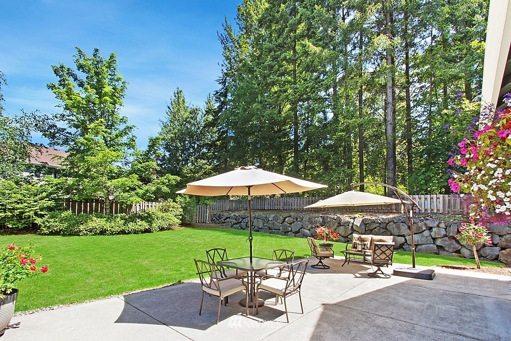 27712 Maple Ridge Way Southeast Maple Valley, WA 98038 - Photo 31 of 36 a patio with a table and chairs under an umbrella