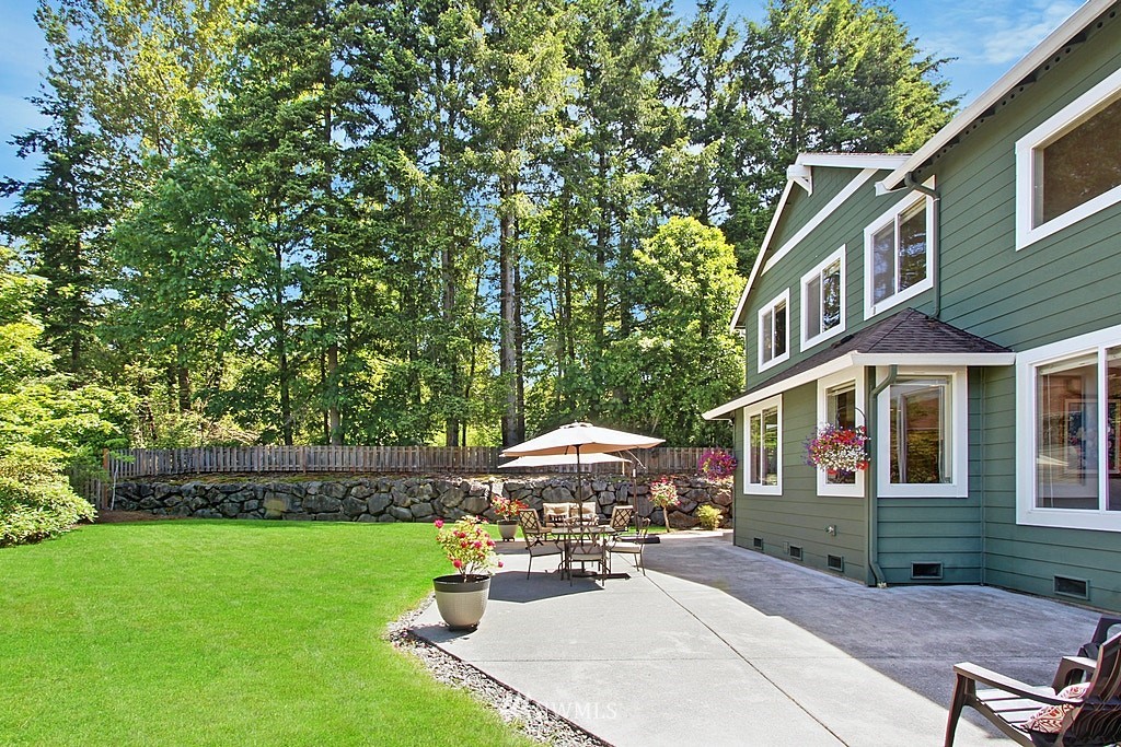 27712 Maple Ridge Way Southeast Maple Valley, WA 98038 - Photo 32 of 36 a view of a patio with a table and chairs under an umbrella