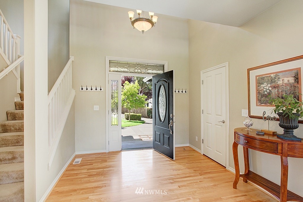 27712 Maple Ridge Way Southeast Maple Valley, WA 98038 - Photo 6 of 36 a view of a hallway to a livingroom with wooden floor and furniture