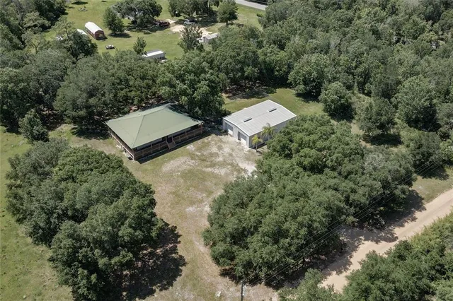 an aerial view of a house with yard and outdoor seating