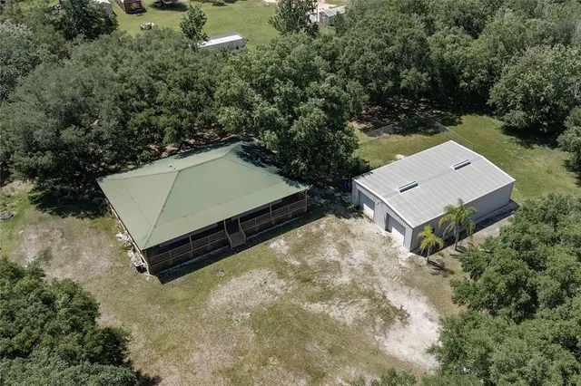 an aerial view of a house with a yard and trees