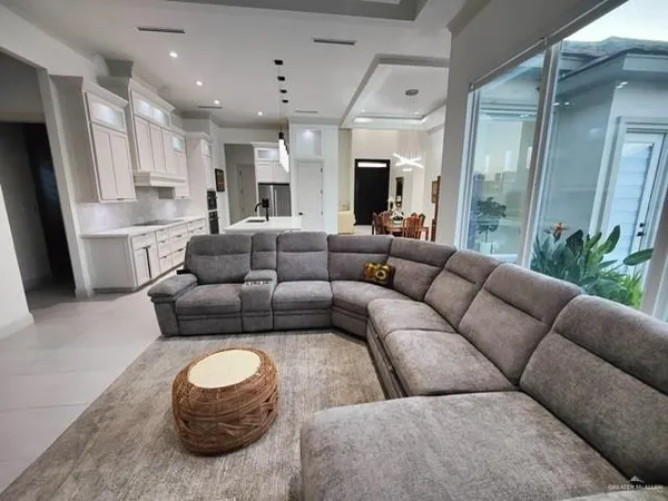 a living room with furniture and a view of kitchen