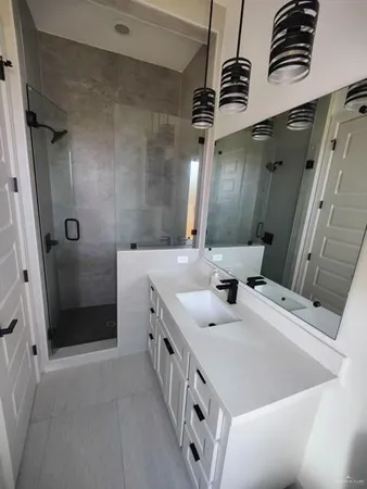 a bathroom with a double vanity sink mirror and shower