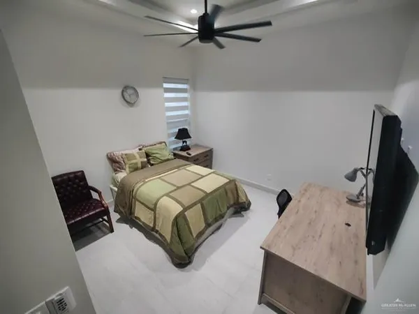 a bedroom with a bed and flat tv screen on the dresser