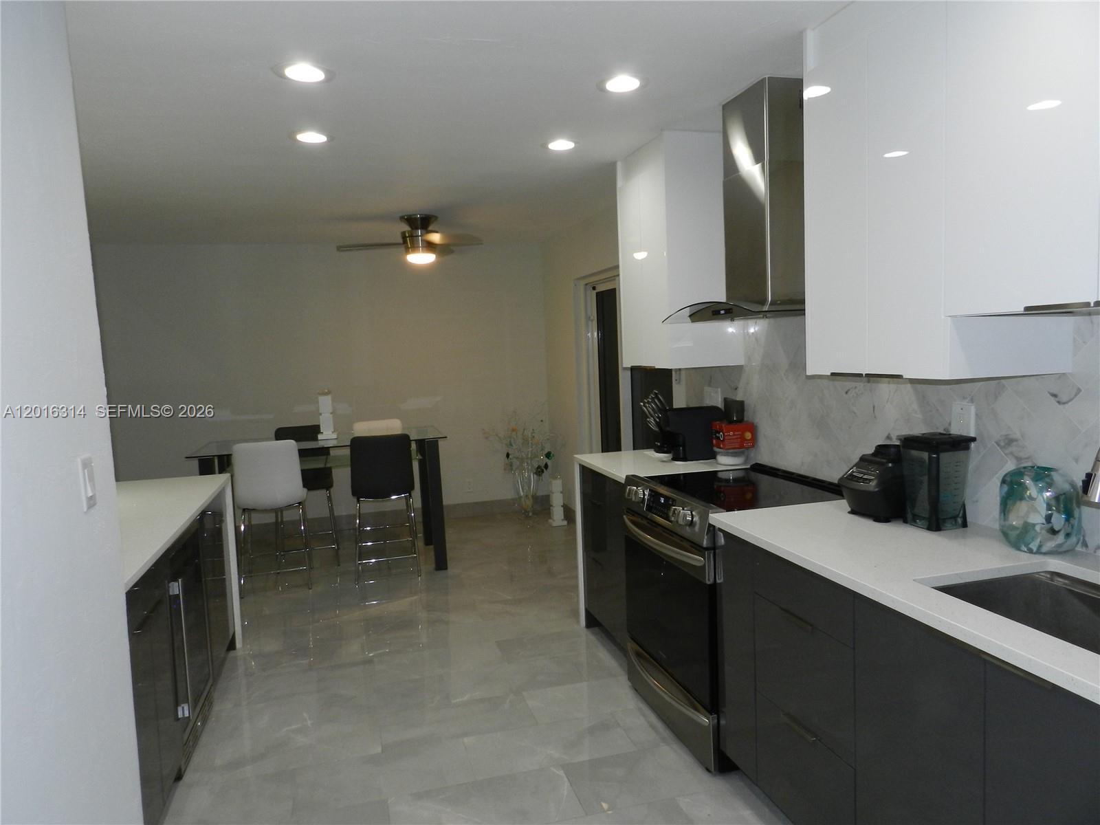 305 Northwest 42nd Street Boca Raton, FL 33431 - Photo 6 of 31 a kitchen with a sink and chairs