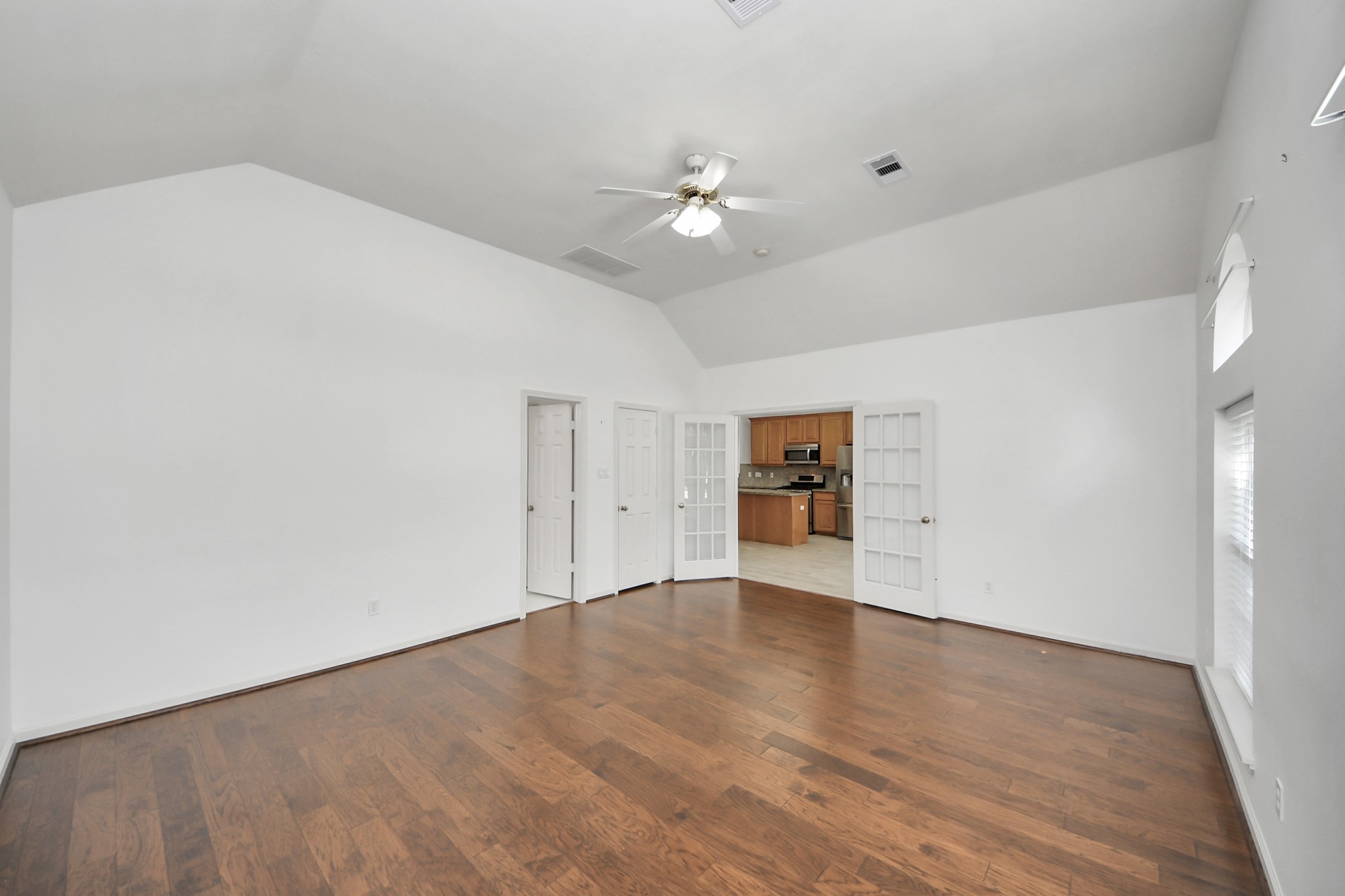 5815 Pheasant Ridge Lane Houston, TX 77041 - Photo 18 of 46 Spacious living area featuring elegant hardwood floors and high ceilings, with French doors opening to a modern kitchen.
