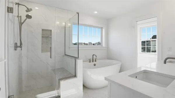 a bathroom with a tub sink shower and mirror