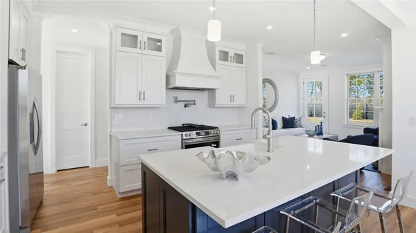 a kitchen with stainless steel appliances granite countertop a kitchen island a stove a table and chairs