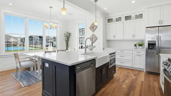 a kitchen with kitchen island granite countertop a sink appliances and cabinets