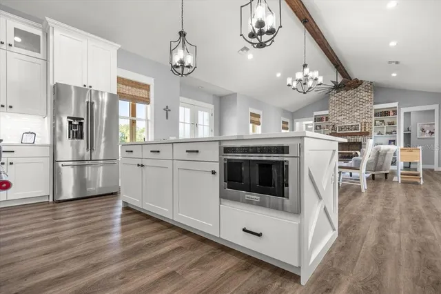 a kitchen with stainless steel appliances granite countertop a stove and white cabinets