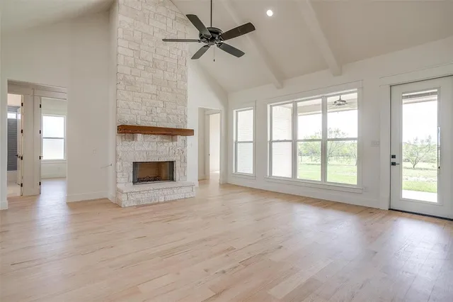 wooden floor fireplace and windows in an empty room