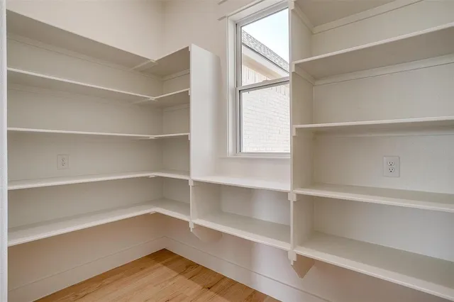 a view of walk in closet with empty racks