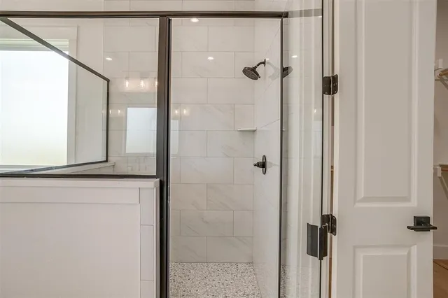 a bathroom with a shower and a glass door