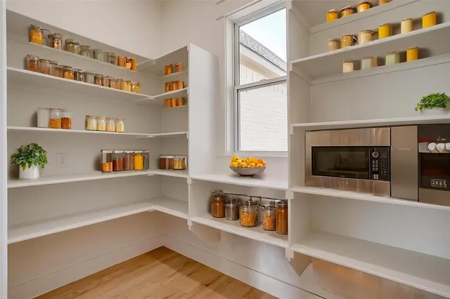 a view of an empty room with wooden floor and shelf