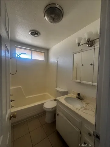 a bathroom with a granite countertop sink a toilet and shower