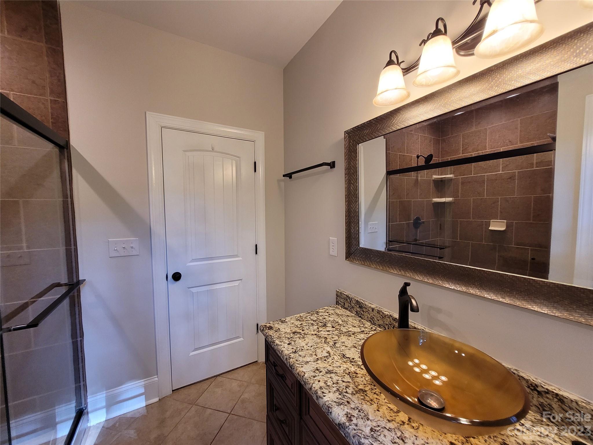 2775 Beechwood Road Denver, NC 28037 - Photo 25 of 26 a bathroom with a granite countertop sink a mirror and shower