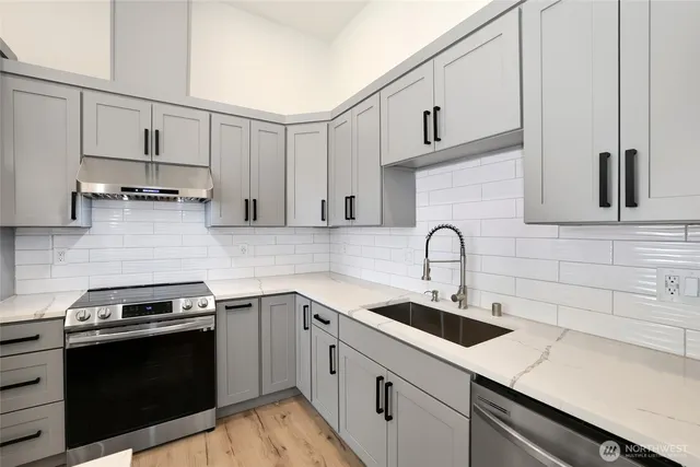 a kitchen with appliances a sink and cabinets