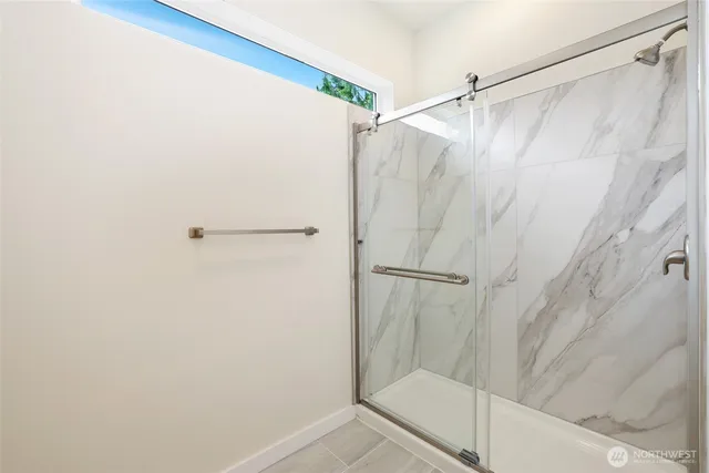 a bathroom with a shower and a glass door