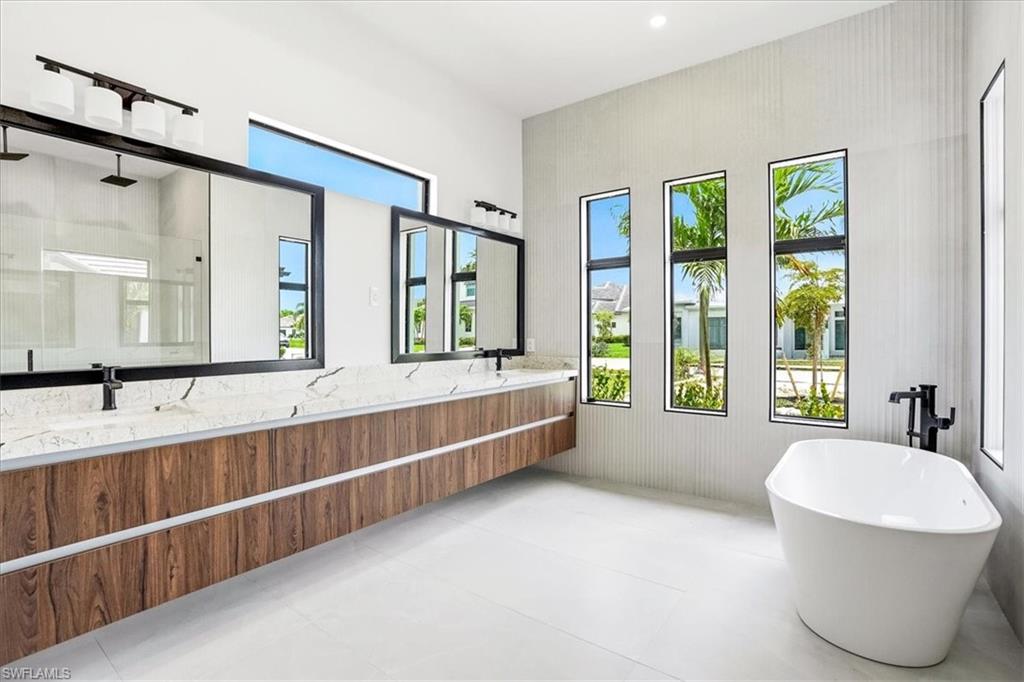 14318 Charthouse Circle Naples, FL 34114 - Photo 10 of 36 a large spacious bathroom with a large tub and large windows