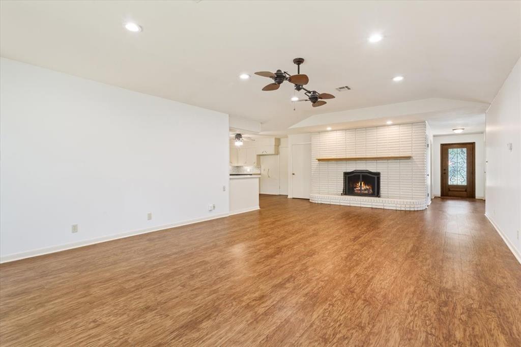 an empty room with a fireplace and wooden floor
