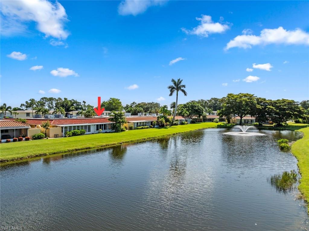 136 Harrison Road, Unit 1 Naples, FL 34112 - Photo 3 of 29 Residential building with a red tile roof and white exterior, situated beside a body of water