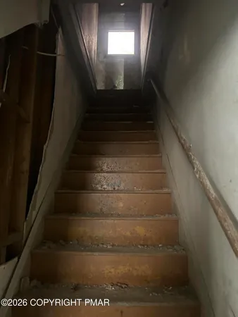 a view of a hallway with wooden floor and windows