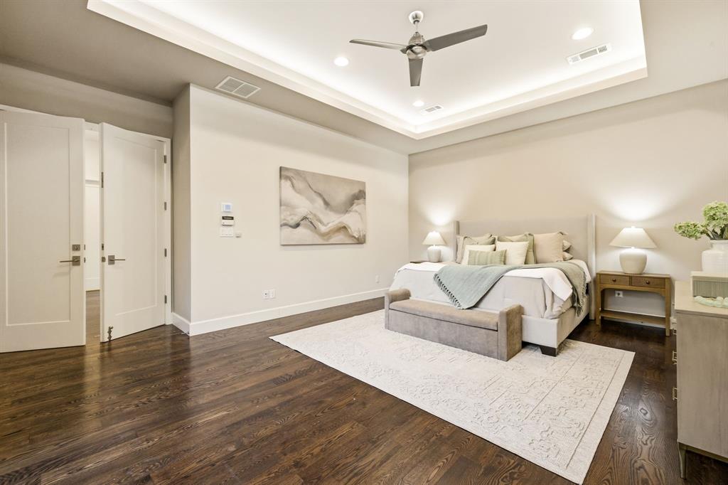 6523 Northwood Road Dallas, TX 75225 - Photo 17 of 36 a spacious bedroom with a bed a couch and a painting on the wall