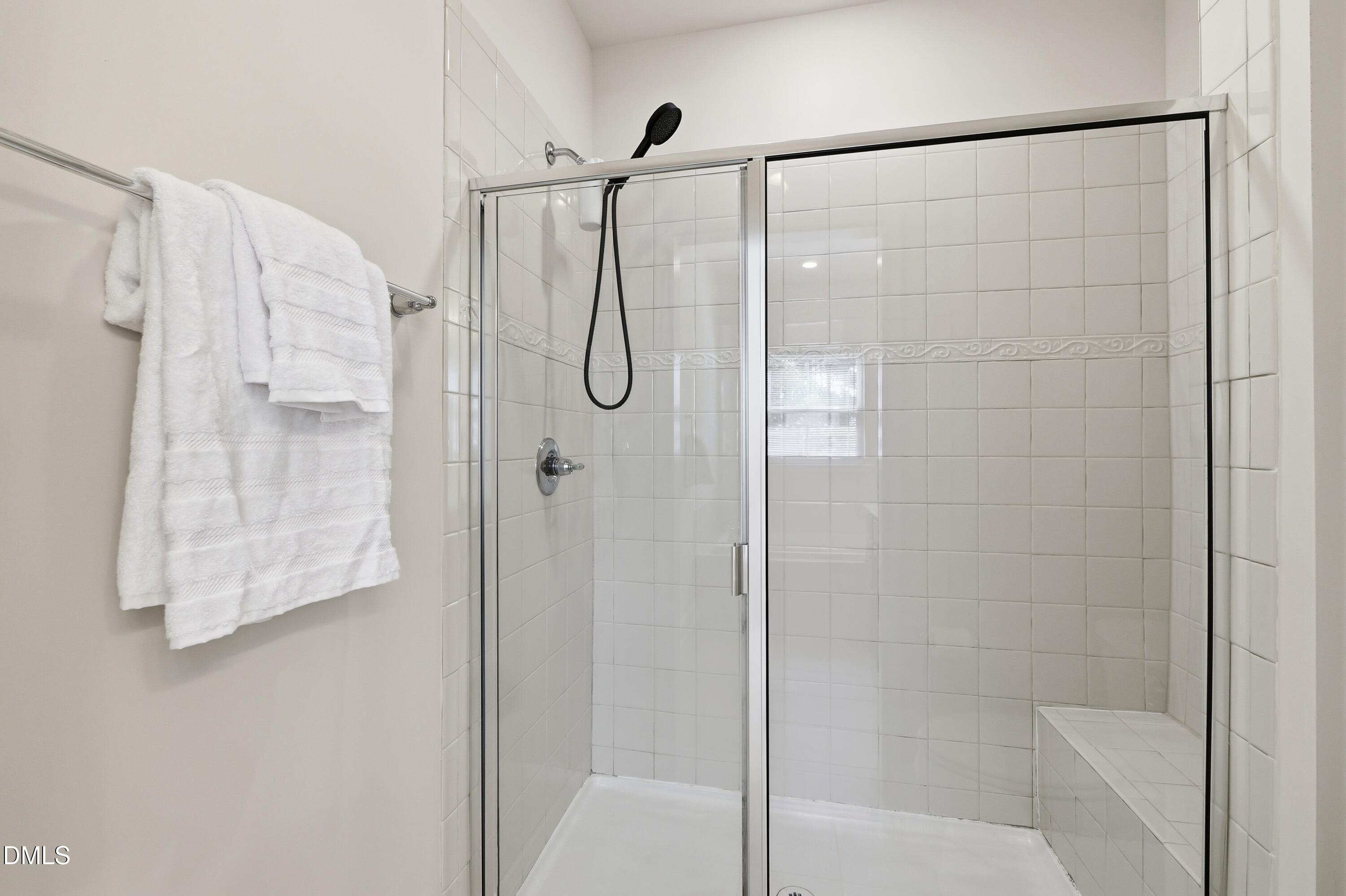 1004 Waymaker Court Apex, NC 27502 - Photo 17 of 30 a bathroom with a glass shower door