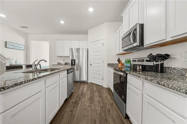 a kitchen with stainless steel appliances granite countertop a sink stove microwave and cabinets