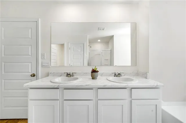 a bathroom with double sink and a mirror