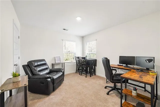 a view of a workspace with furniture and a window