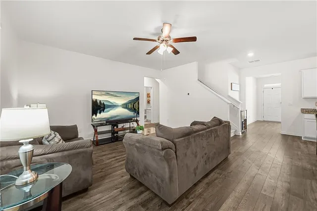 a living room with furniture and a wooden floor