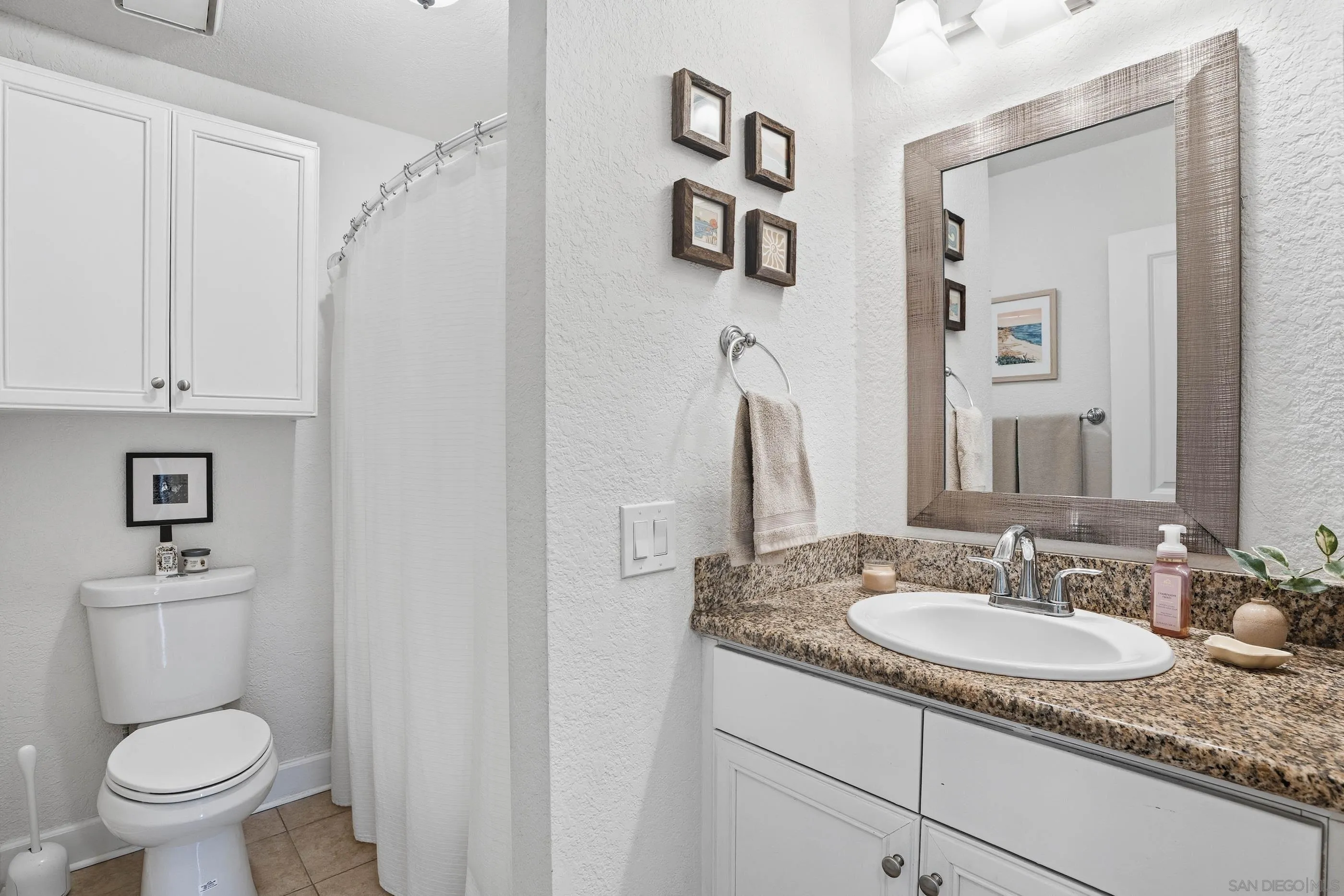1423 Graves Avenue, Unit 240 El Cajon, CA 92021 - Photo 17 of 25 a bathroom with a granite countertop sink toilet and a mirror