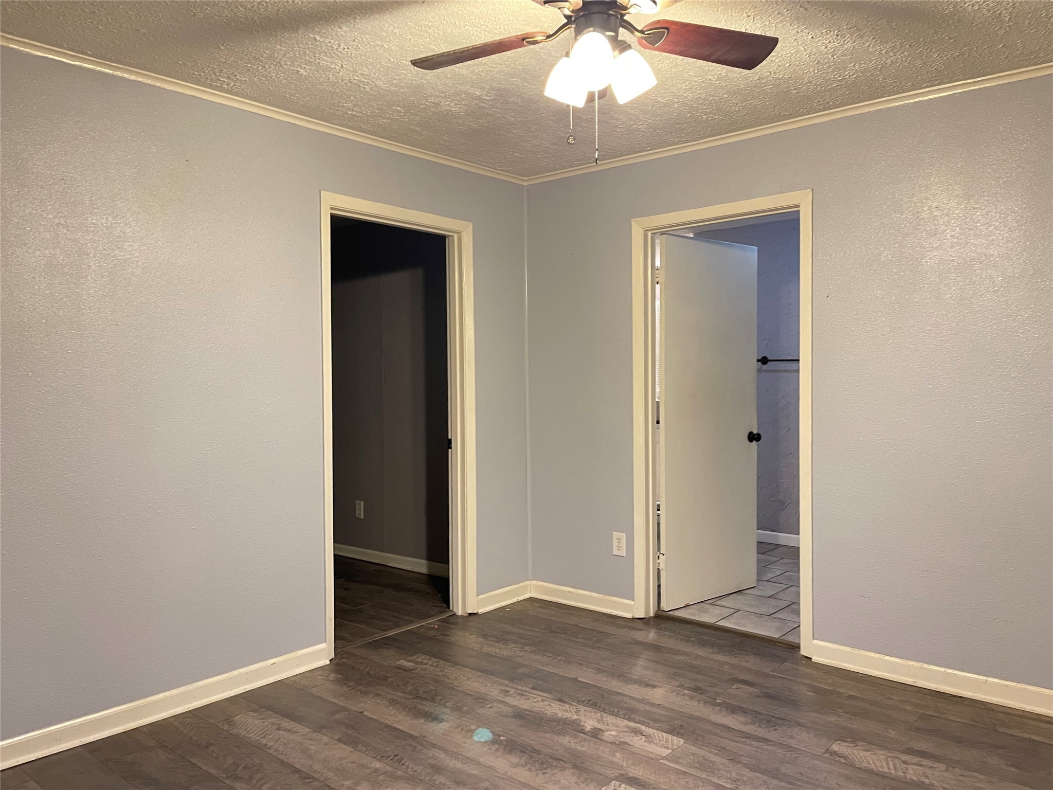 255 Frank Street, Unit AB Kountze, TX 77625 - Photo 12 of 33 an empty room with wooden floor chandelier fan and closet area