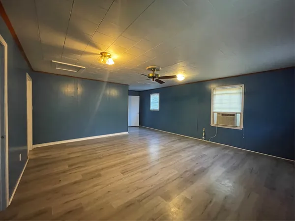 a view of a room with wooden floor and a ceiling fan