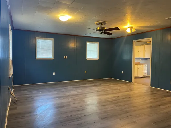 a view of a livingroom with wooden floor and a ceiling fan
