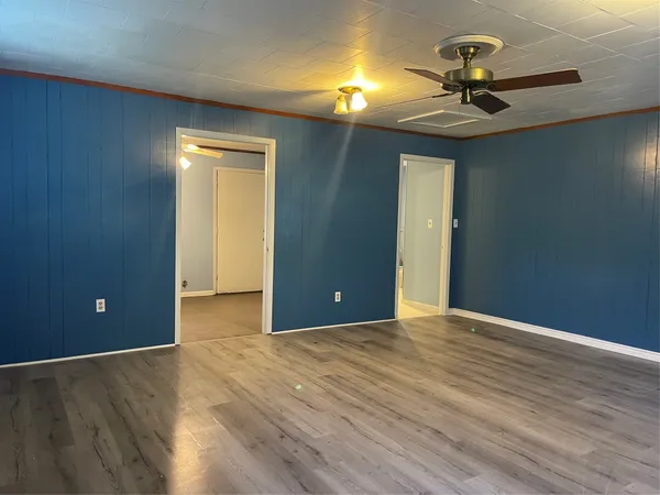a view of a livingroom with wooden floor and ceiling fan
