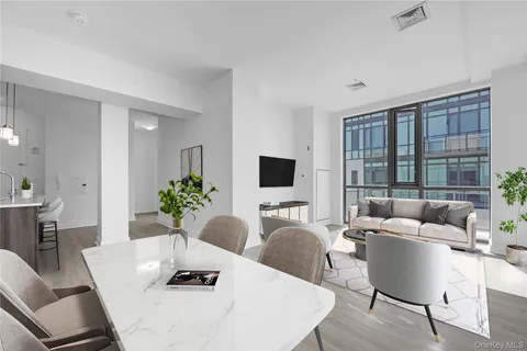 a living room with furniture potted plant and a large window