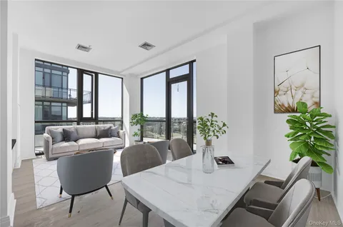 a living room with furniture potted plant and a floor to ceiling window