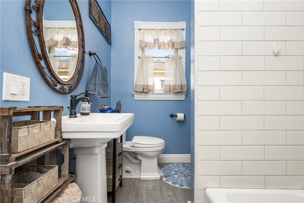 358 North Shaffer Street Orange, CA 92866 - Photo 26 of 45 a bathroom with a sink a mirror a toilet and a window