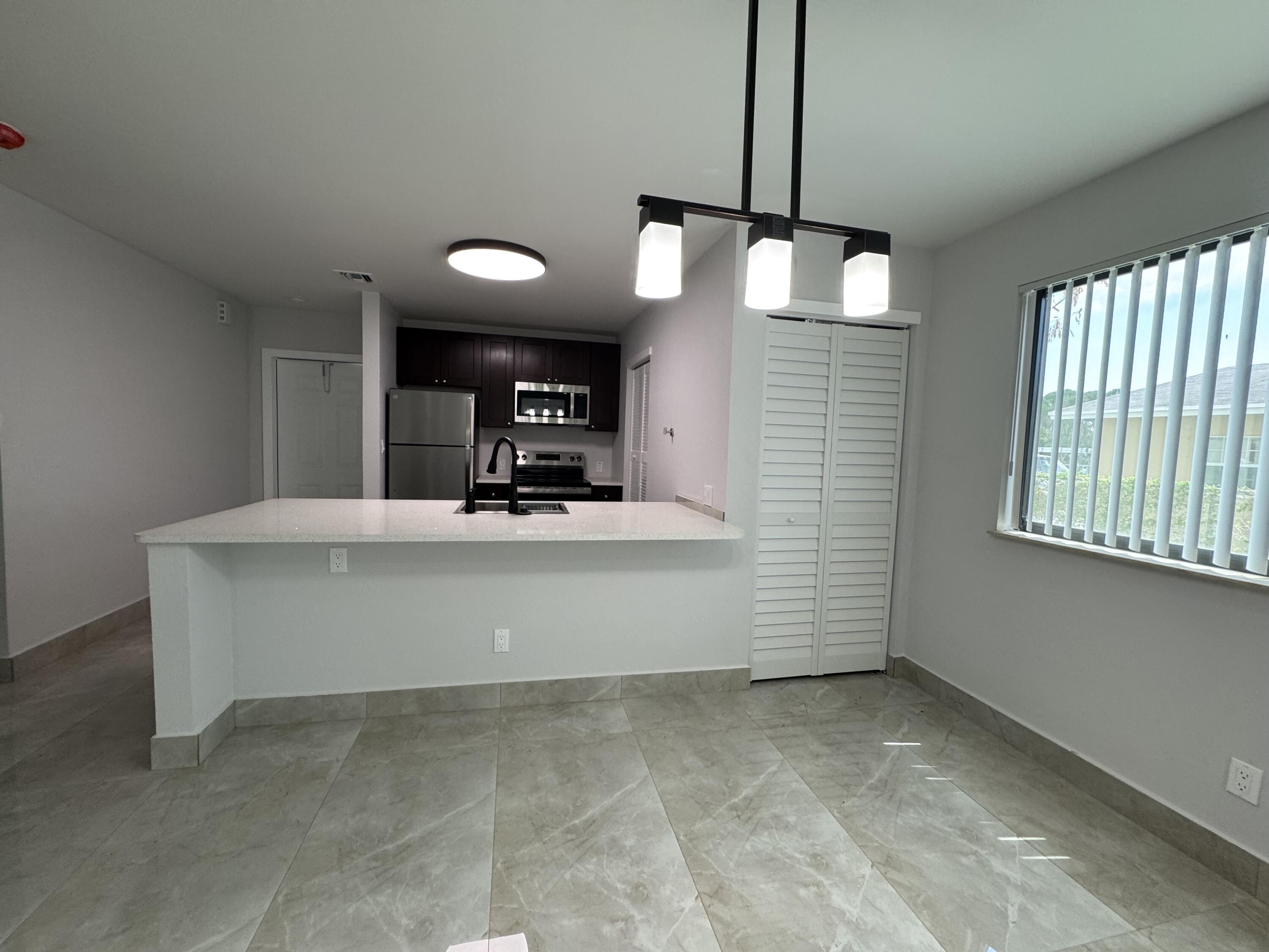400 Northeast 30th Street, Unit 2 Pompano Beach, FL 33064 - Photo 20 of 22 a view of living room kitchen with a sink and chandelier