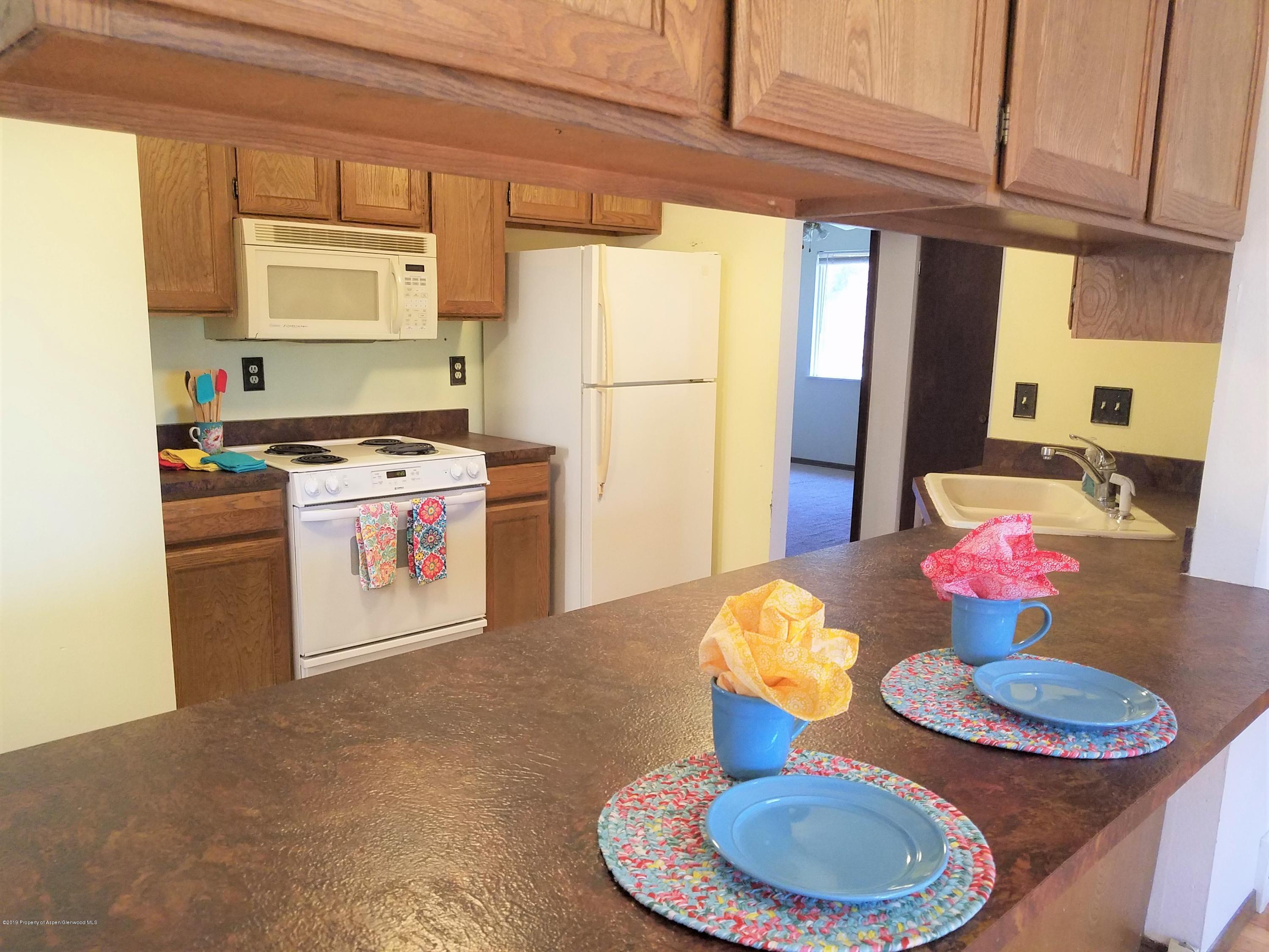 1436 Jays Avenue Rifle, CO 81650 - Photo 10 of 20 a kitchen with stainless steel appliances granite countertop a sink stove and refrigerator