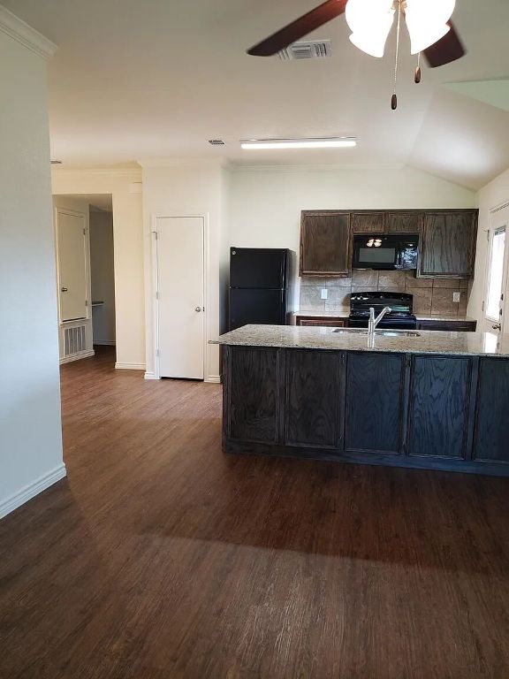 895 Twin Oaks Drive, Unit B Temple, TX 76504 - Photo 5 of 11 a large kitchen with kitchen island granite countertop a sink and a black cabinets