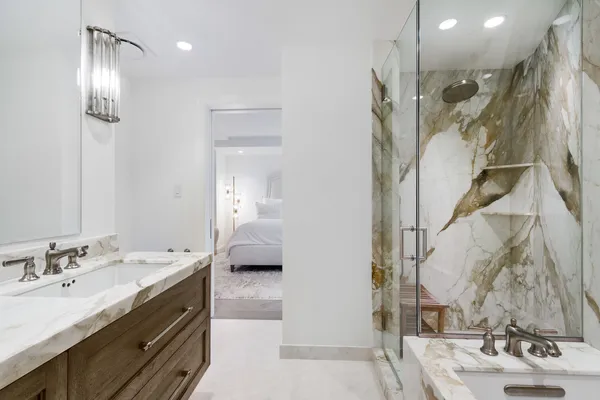 a en suite bathroom with a double vanity sink a mirror and shower
