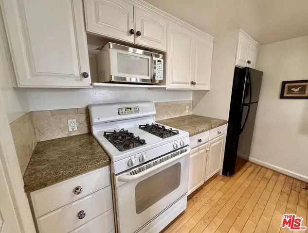 a white stove top oven sitting inside of a kitchen