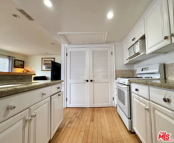 a kitchen with cabinets and wooden floor