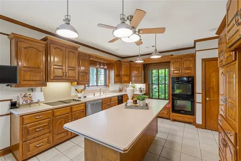 a large kitchen with kitchen island a large counter space appliances and cabinets