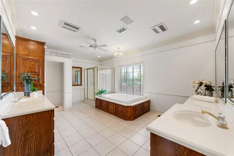 a spacious bathroom with a double vanity sink a large mirror and a bathtub